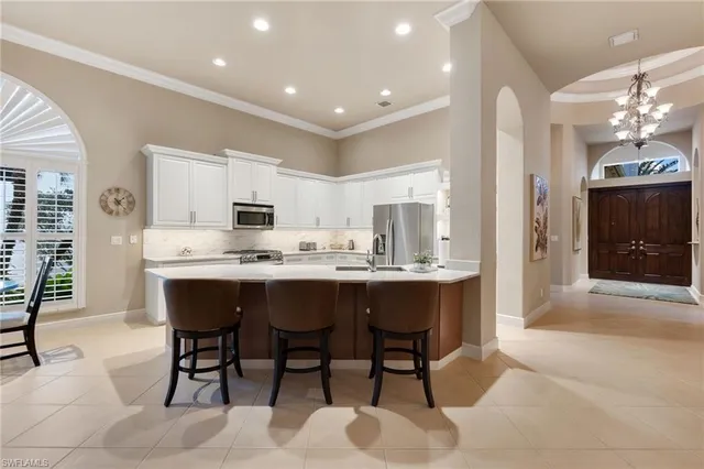 a large kitchen with kitchen island a dining table chairs and a refrigerator