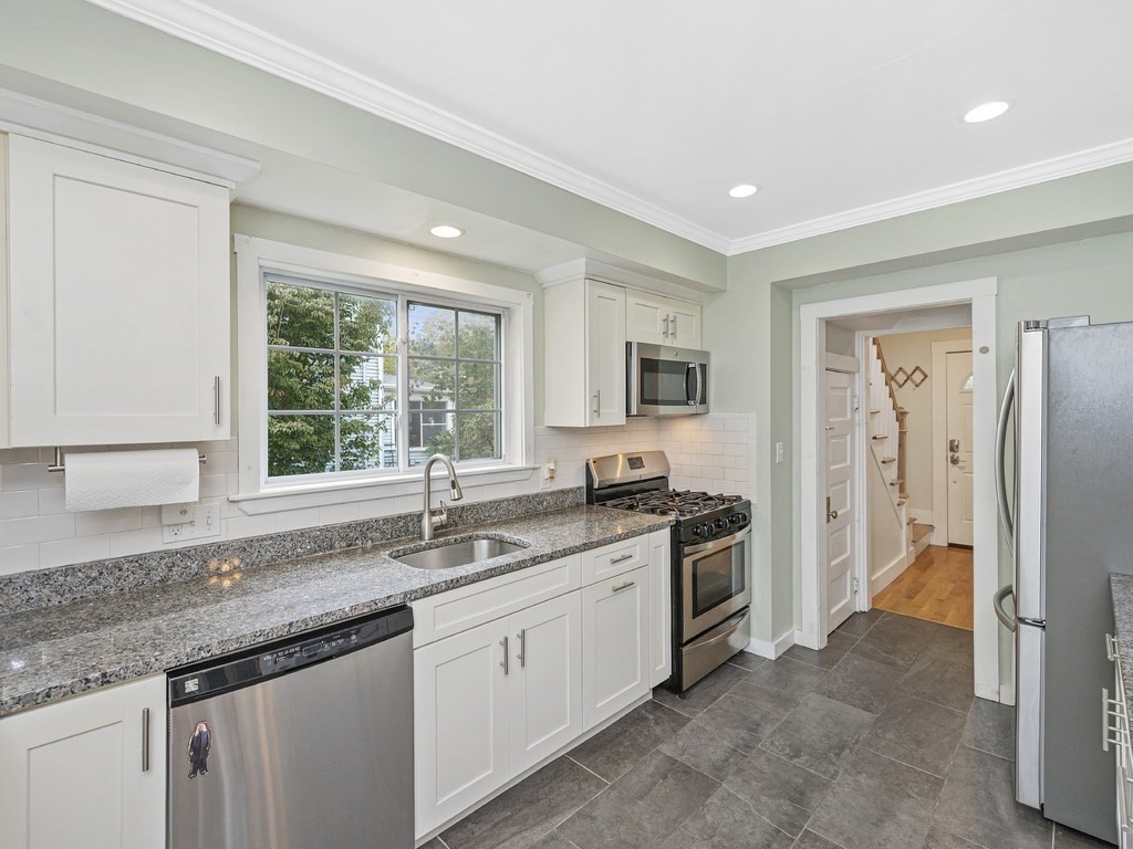 a kitchen that has a sink a window and stainless steel appliances