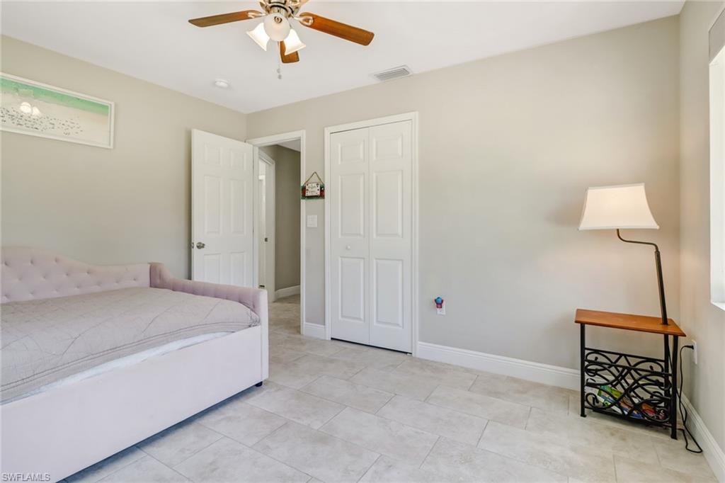 4355 Pine Ridge Road Naples, FL 34119 - Photo 11 of 23 a bedroom with a bed and a chandelier