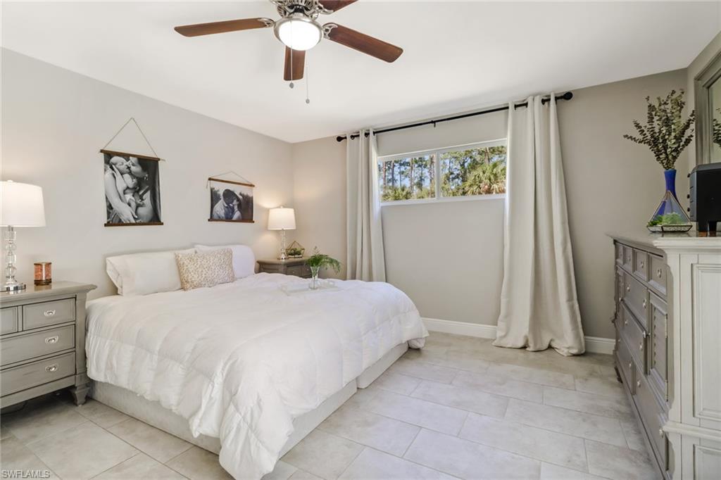 4355 Pine Ridge Road Naples, FL 34119 - Photo 2 of 23 a bedroom with a bed and a chandelier