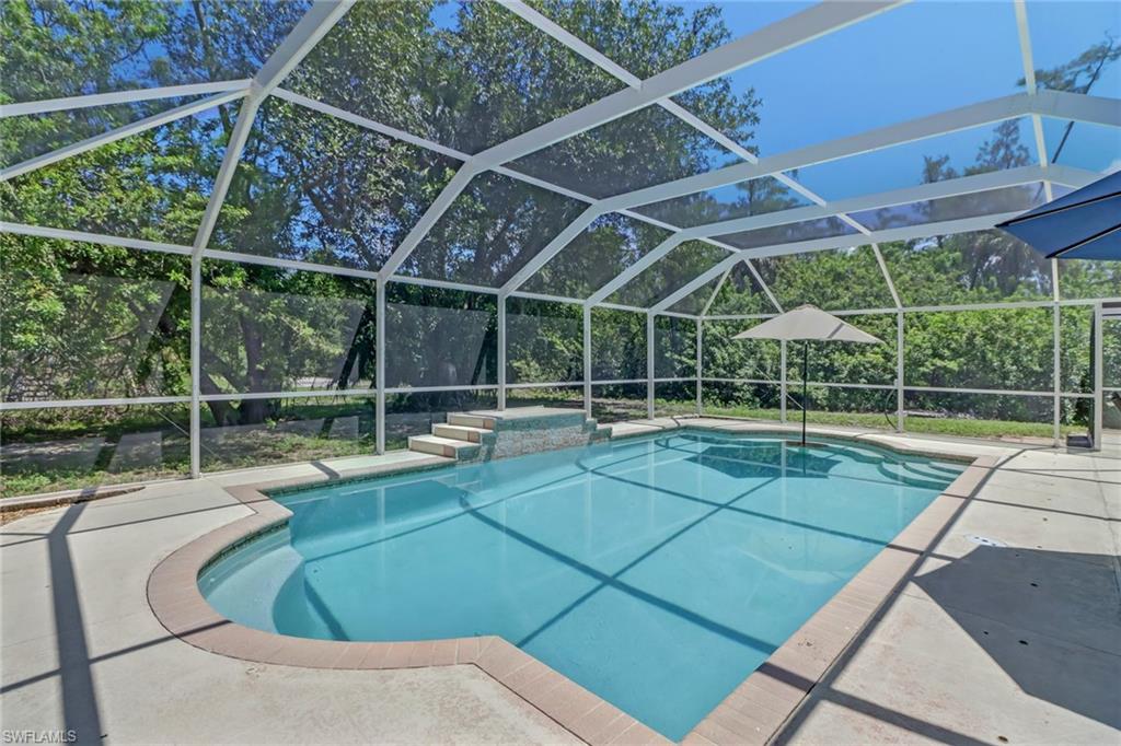 4355 Pine Ridge Road Naples, FL 34119 - Photo 21 of 23 a view of a backyard with swimming pool and wooden fence