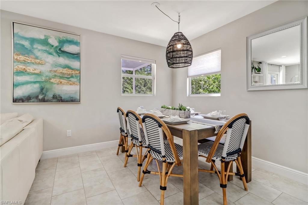 4355 Pine Ridge Road Naples, FL 34119 - Photo 8 of 23 a view of a dining room with furniture wooden floor and a chandelier