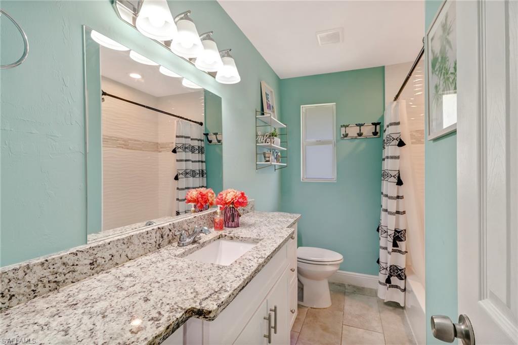 4355 Pine Ridge Road Naples, FL 34119 - Photo 9 of 23 a bathroom with a granite countertop sink a toilet and shower