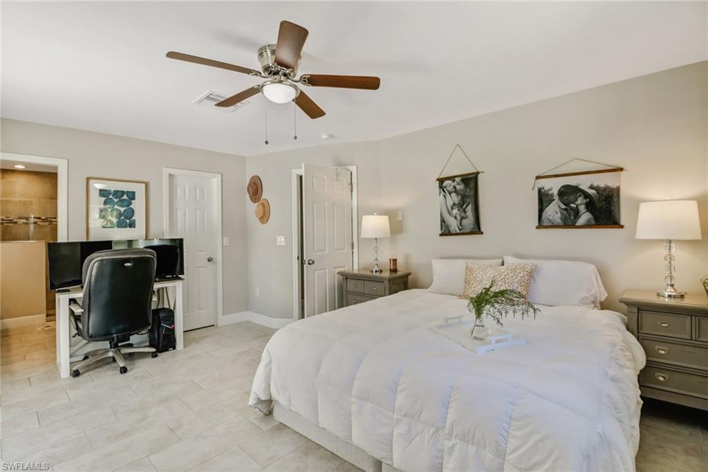 4355 Pine Ridge Road Naples, FL 34119 - Photo 10 of 23 a bedroom with a bed a desk and chair