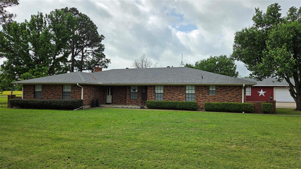 a view of a brick house with a yard