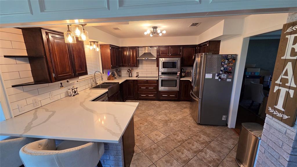 338 Travis Road Decatur, TX 76234 - Photo 11 of 40 a kitchen with a refrigerator and a sink