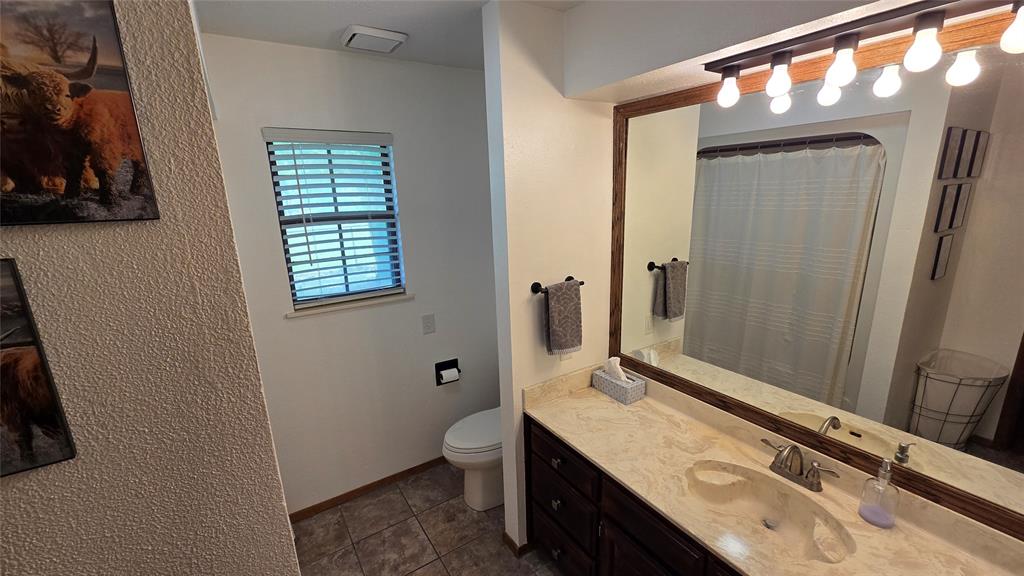 338 Travis Road Decatur, TX 76234 - Photo 18 of 40 a bathroom with a granite countertop sink toilet and shower