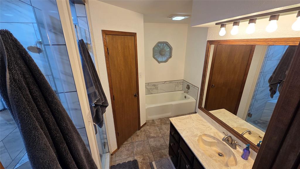 338 Travis Road Decatur, TX 76234 - Photo 23 of 40 a bathroom with a tub and a shower