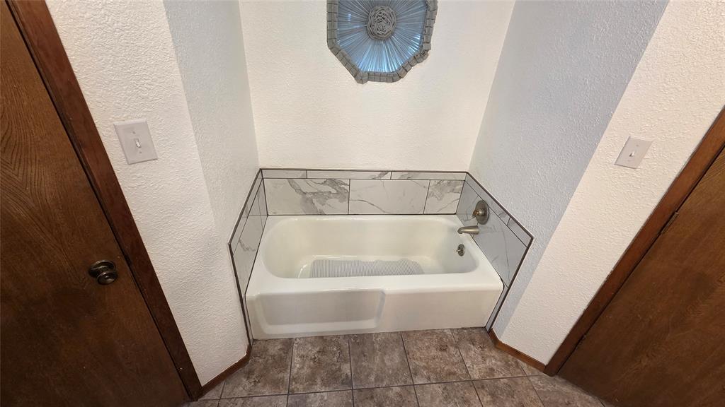 338 Travis Road Decatur, TX 76234 - Photo 24 of 40 a white bath tub sitting in a bathroom