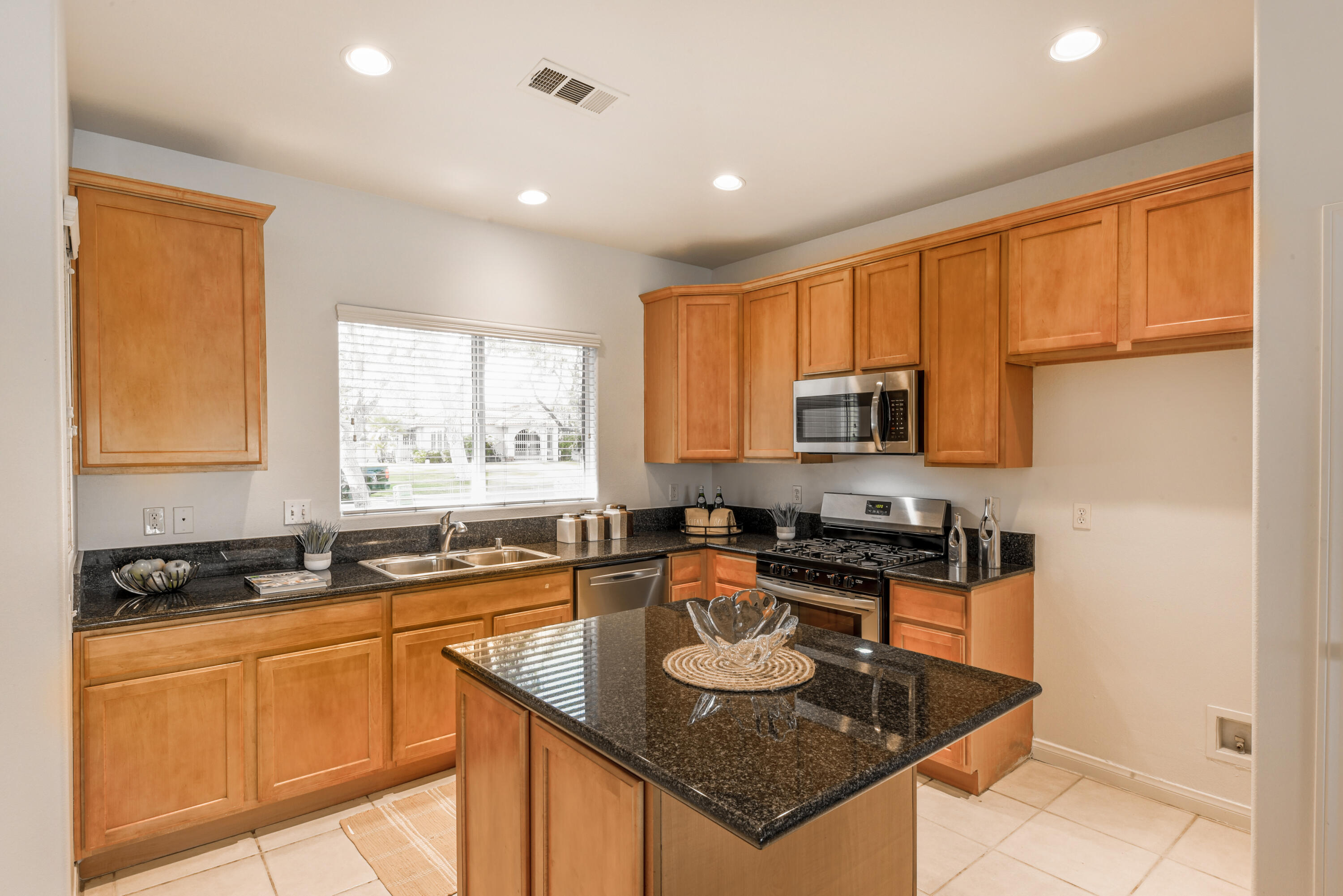 82346 Lancaster Way, Unit 125 Indio, CA 92201 - Photo 11 of 34 a kitchen with stainless steel appliances granite countertop a stove a sink a microwave a refrigerator and cabinets