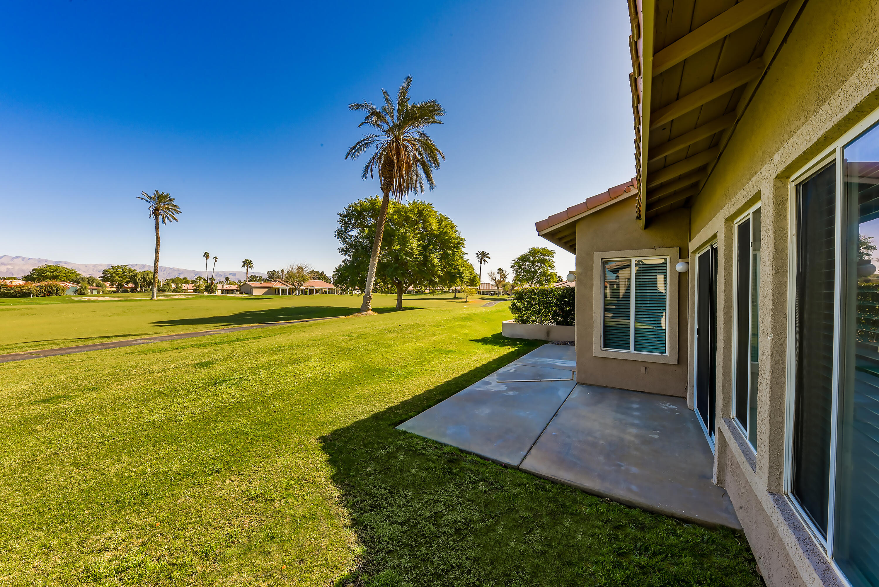 82346 Lancaster Way, Unit 125 Indio, CA 92201 - Photo 21 of 34 a view of a patio with a table and chairs under an umbrella