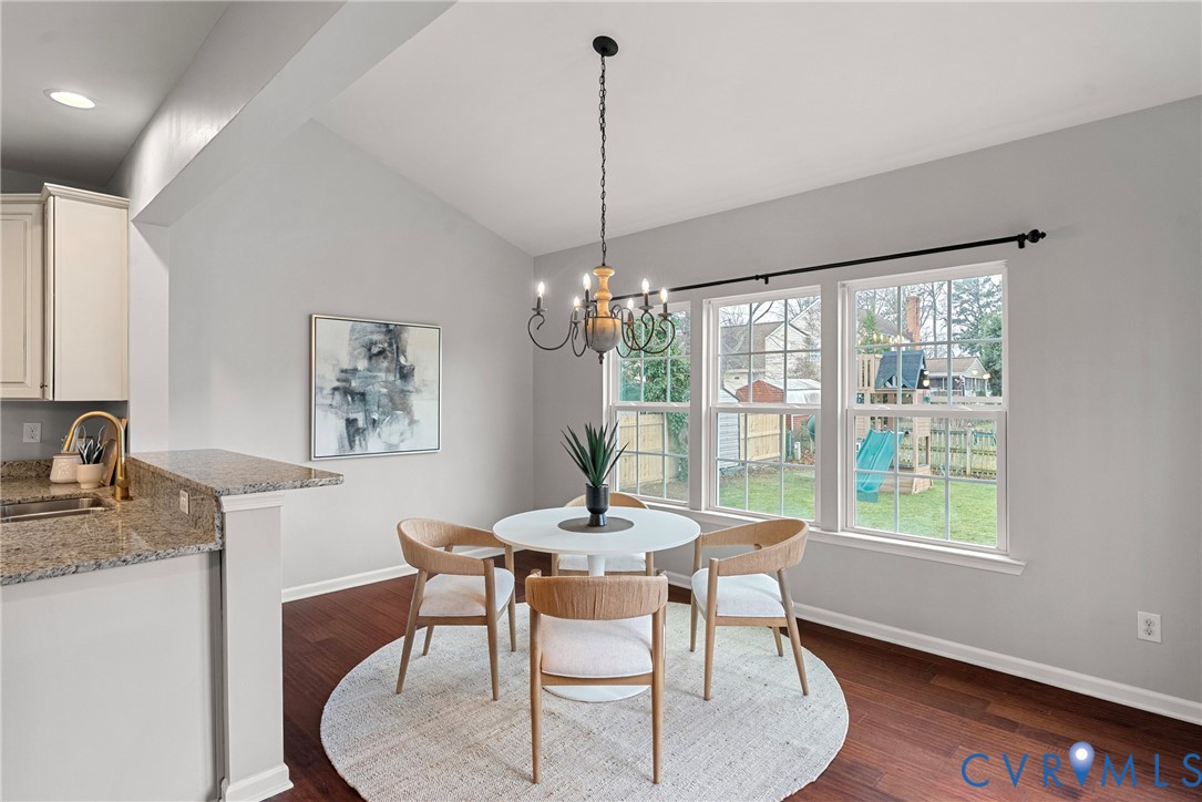 8316 Forge Road Henrico, VA 23228 - Photo 14 of 43 a dining room with furniture a chandelier and wooden floor
