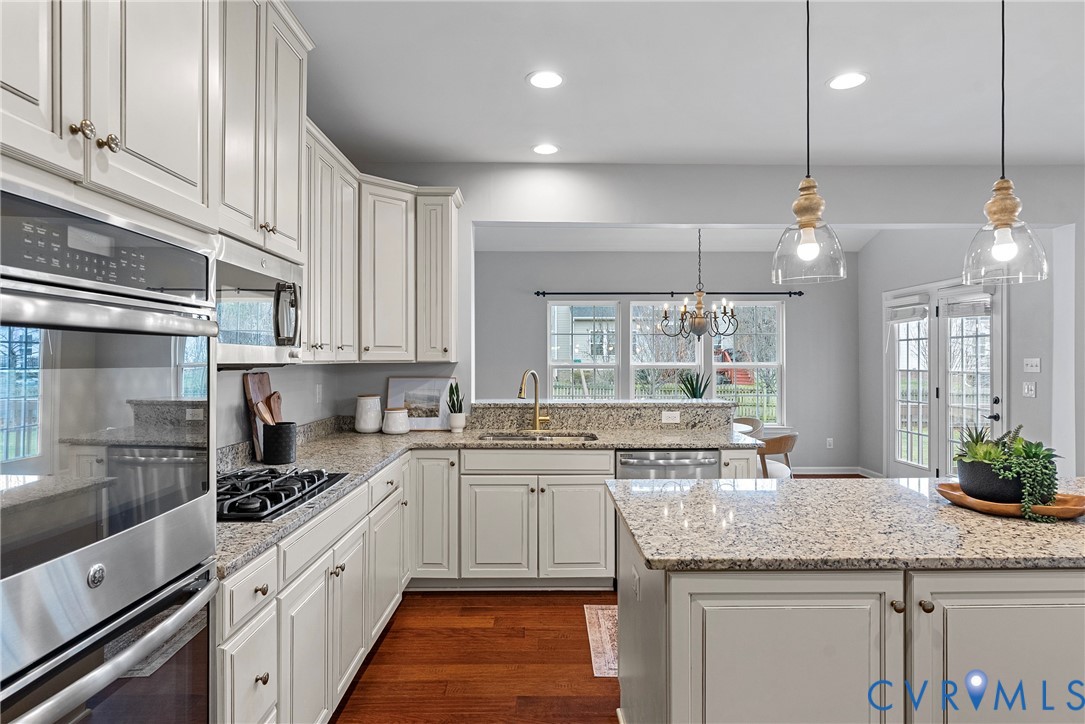 8316 Forge Road Henrico, VA 23228 - Photo 5 of 43 a kitchen with granite countertop a sink stainless steel appliances and white cabinets