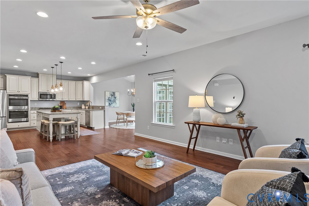 8316 Forge Road Henrico, VA 23228 - Photo 10 of 43 a living room with furniture a rug kitchen view and a chandelier