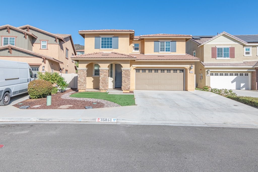 a front view of a building with a yard and garage
