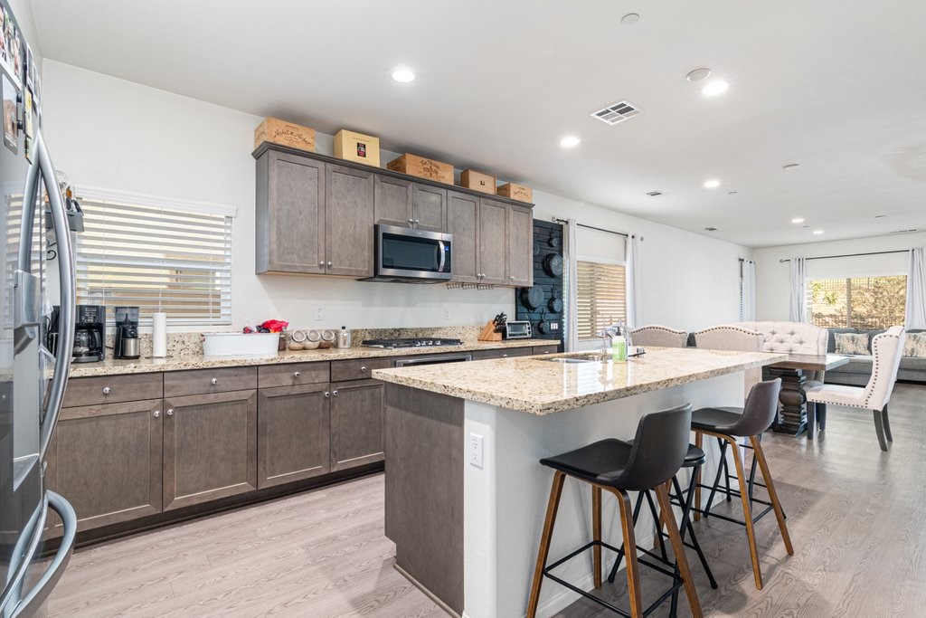 35851 Esperia Way Fallbrook, CA 92028 - Photo 5 of 28 a kitchen with cabinets a sink dishwasher a dining table and chairs
