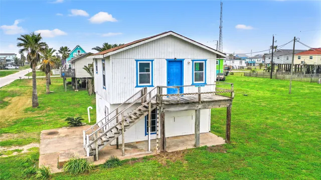 a view of a house with a yard chairs and table in patio