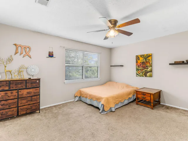 a bedroom with a bed and ceiling fan