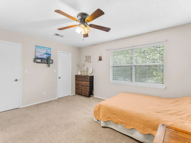 a bathroom with a granite countertop sink a toilet and a mirror