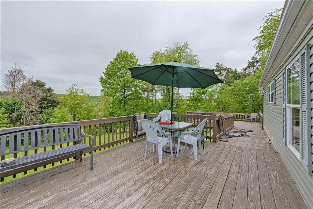 3942 Utah Court Export, PA 15632 - Photo 20 of 24 a view of deck with dinning table and chair under an umbrella with wooden floor