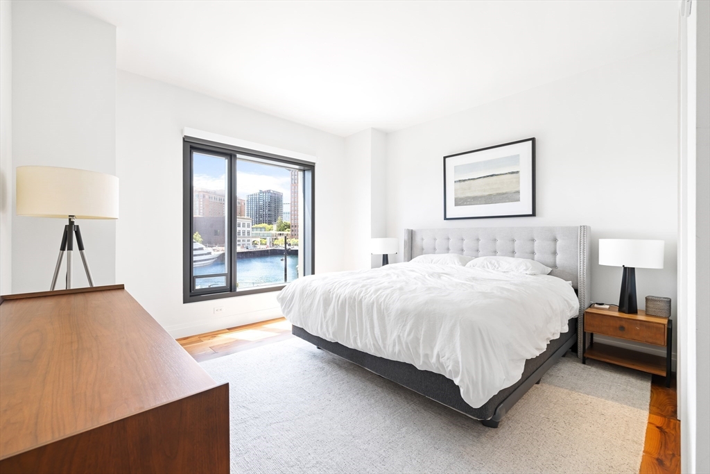 300 Pier 4 Blvd., Unit 3K Boston, MA 02210 - Photo 12 of 24 a large bed sitting in a bedroom next to a window