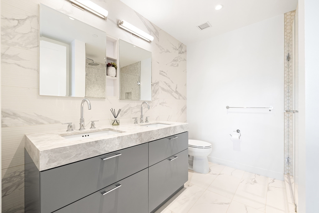 300 Pier 4 Blvd., Unit 3K Boston, MA 02210 - Photo 15 of 24 a bathroom with a toilet a sink and a mirror