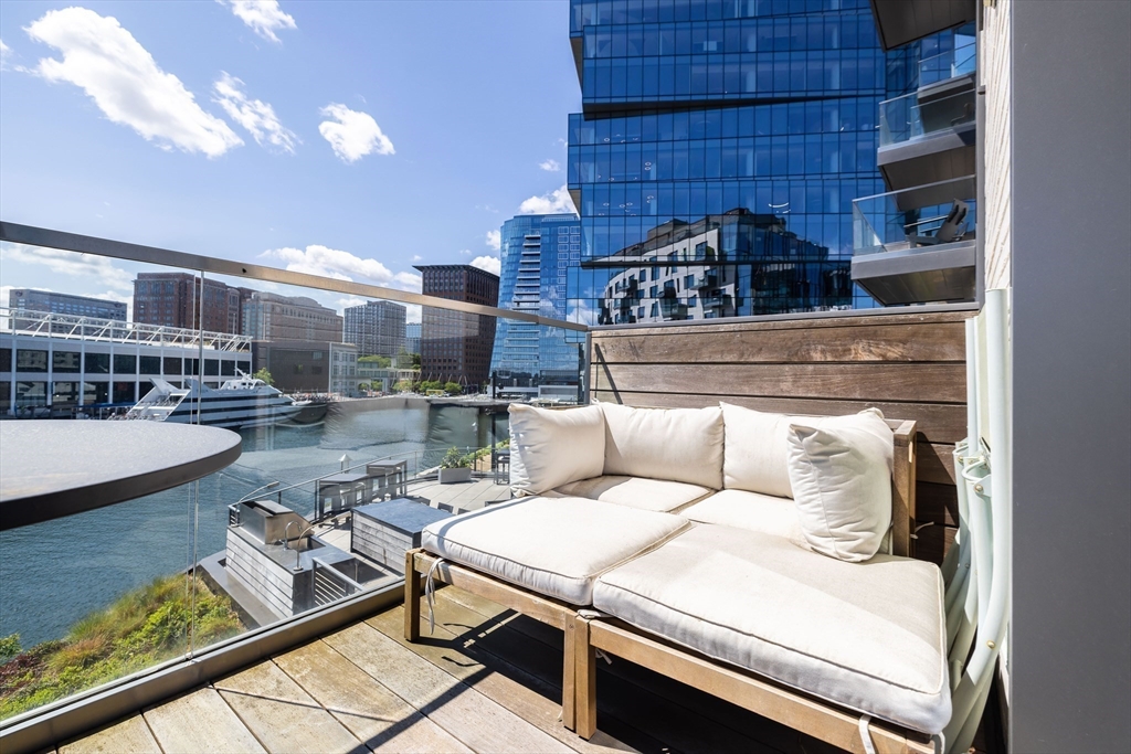 300 Pier 4 Blvd., Unit 3K Boston, MA 02210 - Photo 10 of 24 a living room with couches and kitchen view with wooden floor