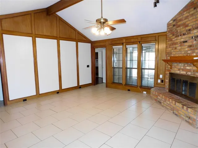 a view of an empty room with a fireplace and a window