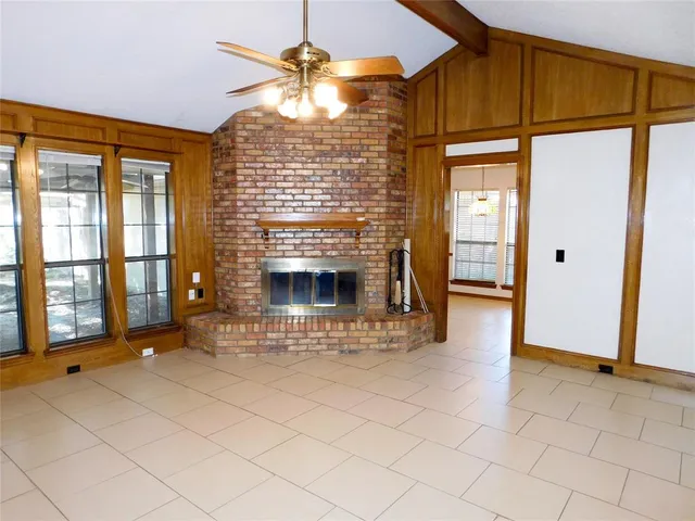 a view of an empty room with a fireplace and a window