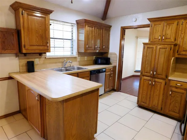 a kitchen with a refrigerator sink and cabinets