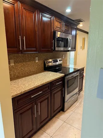 a kitchen with granite countertop wooden cabinets and stainless steel appliances