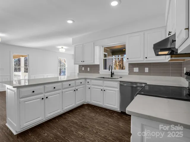 a kitchen with granite countertop white cabinets white stainless steel appliances with a sink and dishwasher