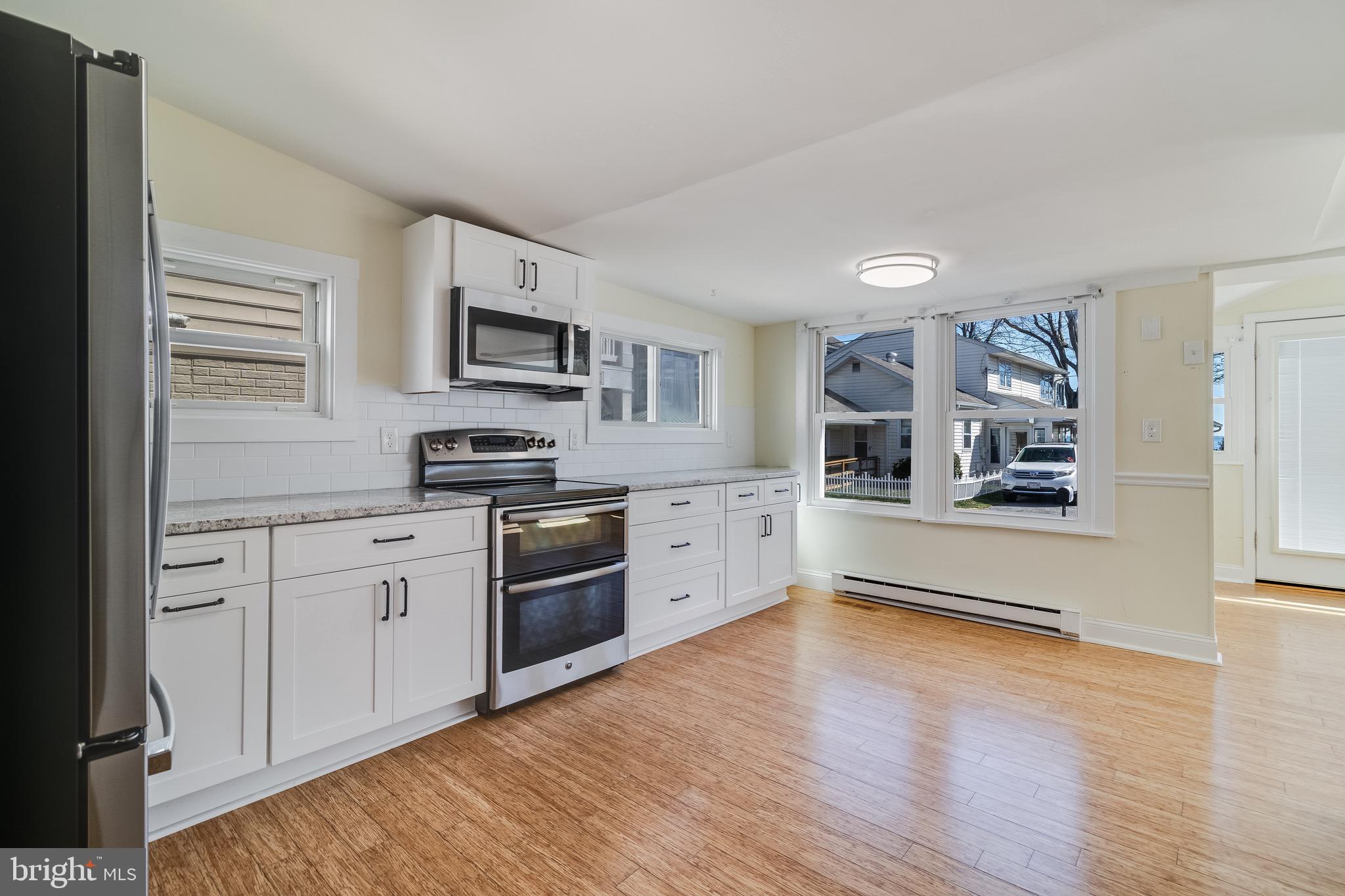 8227 Bayside Road Chesapeake Beach, MD 20732 - Photo 18 of 27 a kitchen with granite countertop a refrigerator and a stove top oven