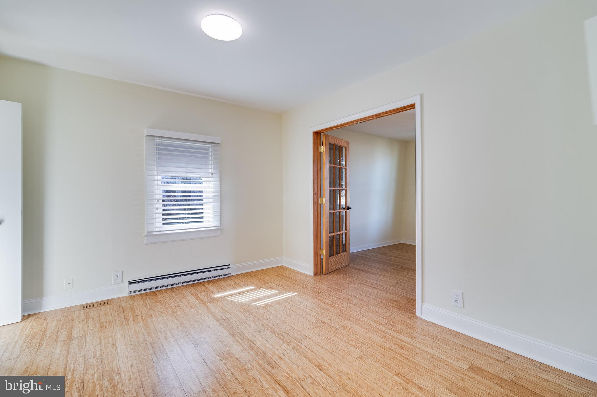 8227 Bayside Road Chesapeake Beach, MD 20732 - Photo 19 of 27 an empty room with wooden floor and windows