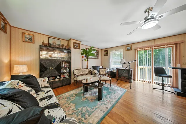 a living room with furniture and a flat screen tv with wooden floor