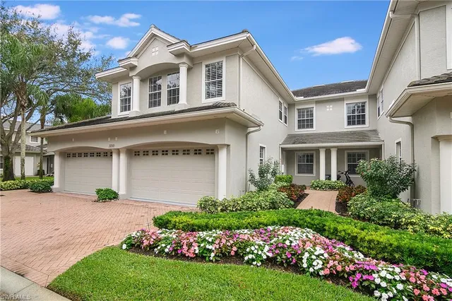 a front view of a house with a garden and plants