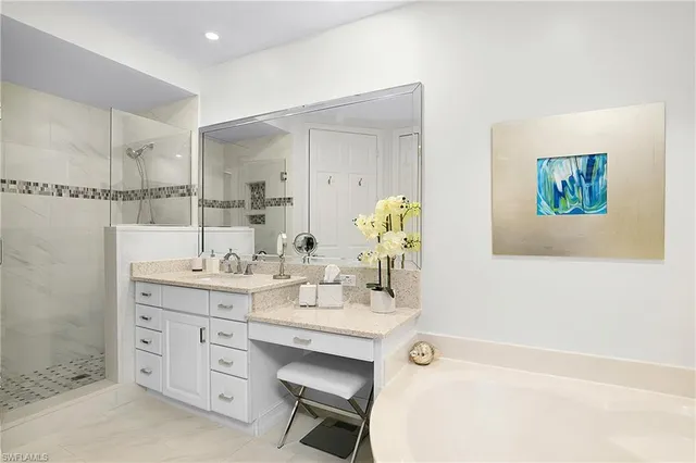 a bathroom with a tub sink and mirror