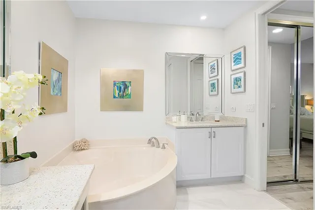 a bathroom with a tub a sink and a mirror