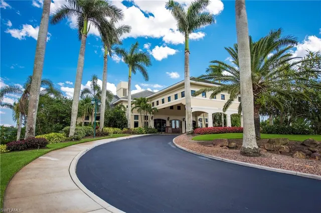a front view of a house with a yard and palm trees