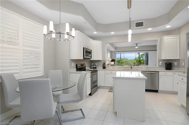 a kitchen with cabinets and chairs