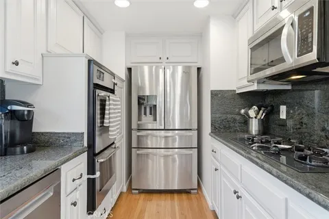 a kitchen with a refrigerator stove and cabinets
