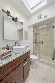 a bathroom with a granite countertop sink toilet and shower