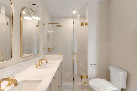 a bathroom with a granite countertop sink toilet and shower