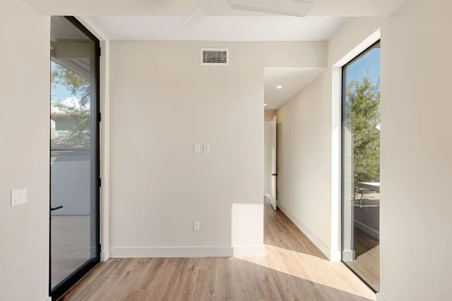 a view of a hallway with wooden floor and entryway