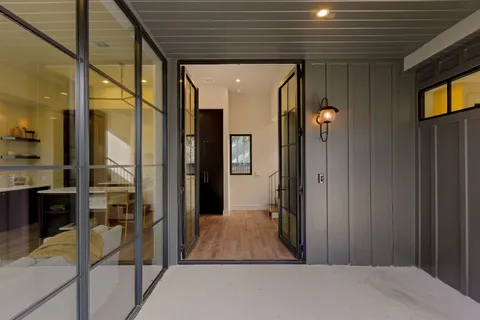 a view of a hallway with wooden floor and staircase