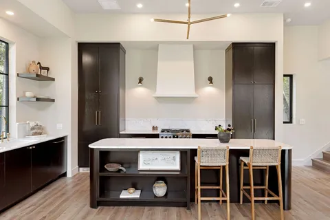 a kitchen with a table chairs refrigerator and cabinets