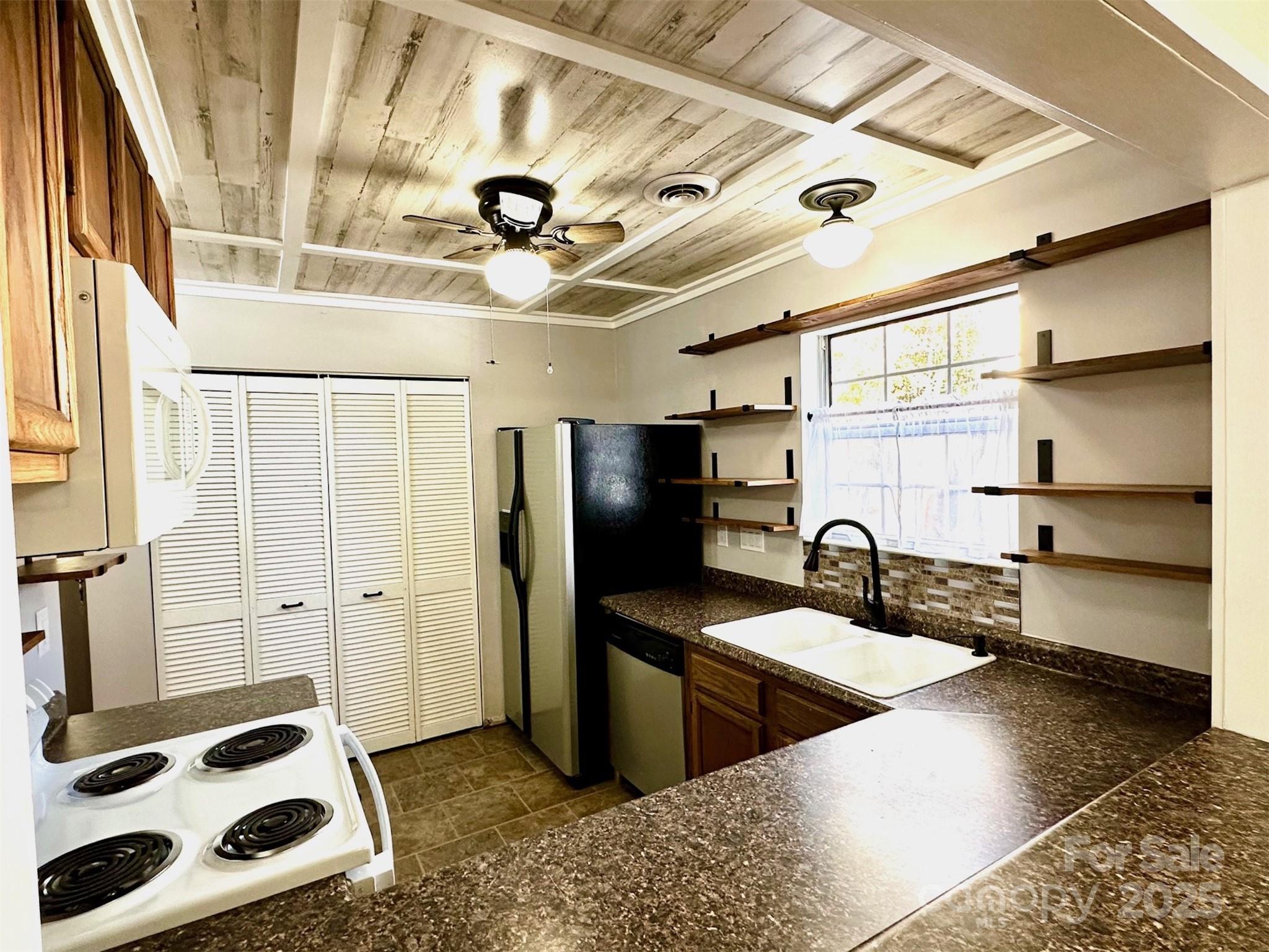 3 Rocking Porch Road Asheville, NC 28805 - Photo 12 of 25 a kitchen with stainless steel appliances kitchen island granite countertop a sink and a refrigerator