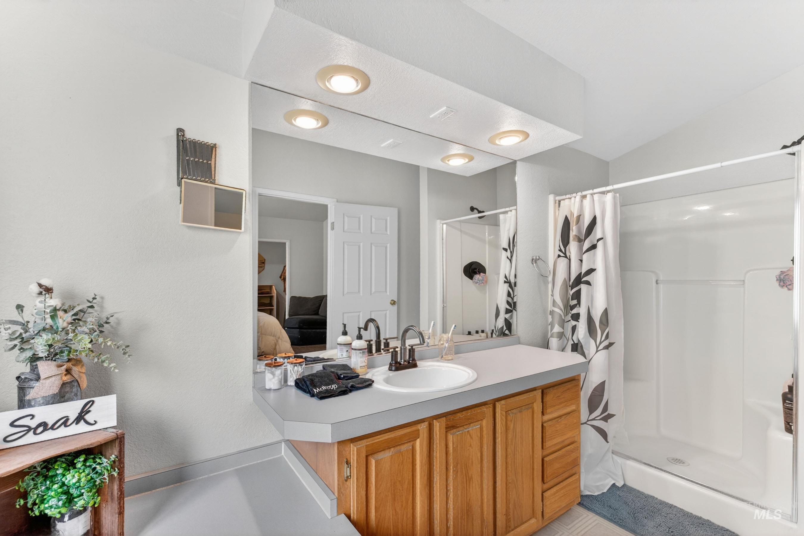 151 Cow Creek Road Lucile, ID 83542 - Photo 27 of 50 Bathroom featuring a single-sink vanity with wood-finish cabinetry and a light-toned countertop