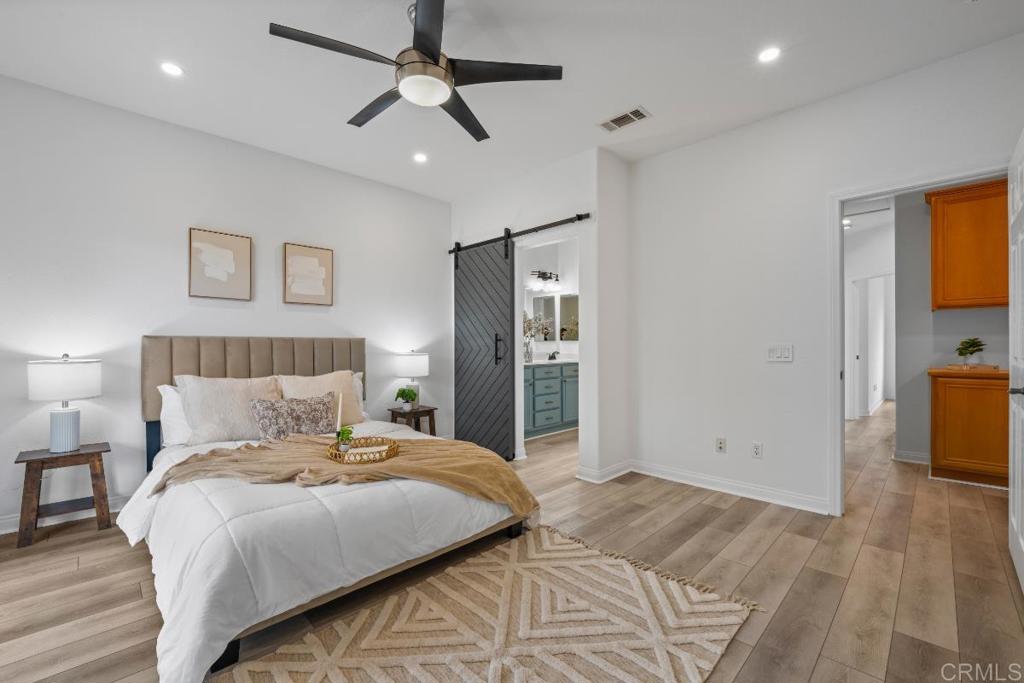 5511 Old Ranch Road, Unit 19 Oceanside, CA 92057 - Photo 15 of 32 a bedroom with a large bed and a chandelier