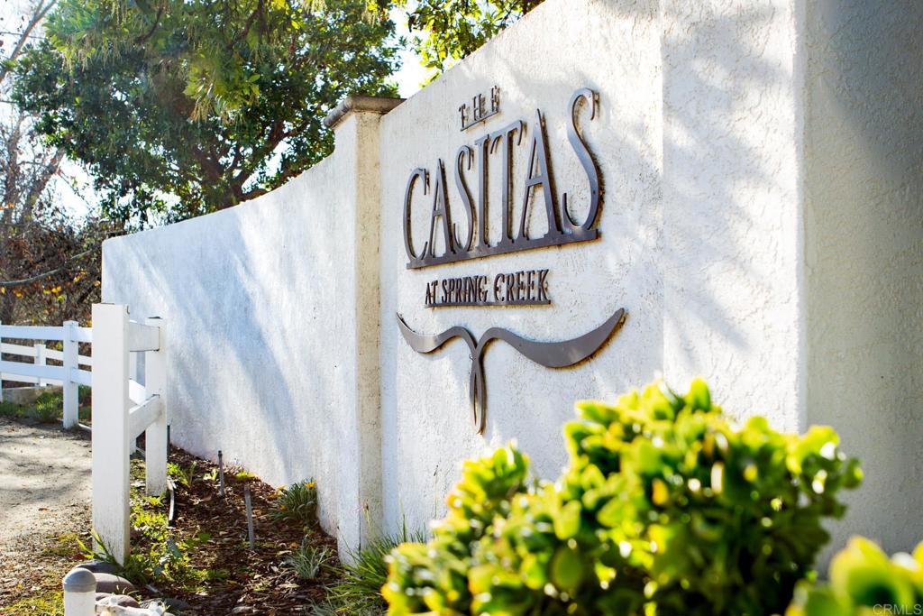 5511 Old Ranch Road, Unit 19 Oceanside, CA 92057 - Photo 24 of 32 a street sign that is next to a bunch of flowers